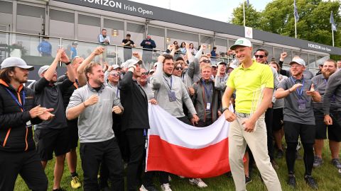 Meronk poses with the Polish flag after his maiden Tour victory.