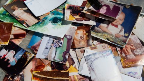 On a table outside his house are photos that Charlie hopes to save.