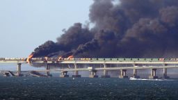 Black smoke billows from a fire on the Kerch bridge that links Crimea to Russia, after a truck exploded, near Kerch, on October 8, 2022. - Moscow announced on October 8, 2022 that a truck exploded igniting a huge fire and damaging the key Kerch bridge -- built as Russia's sole land link with annexed Crimea -- and vowed to find the perpetrators, without immediately blaming Ukraine. 