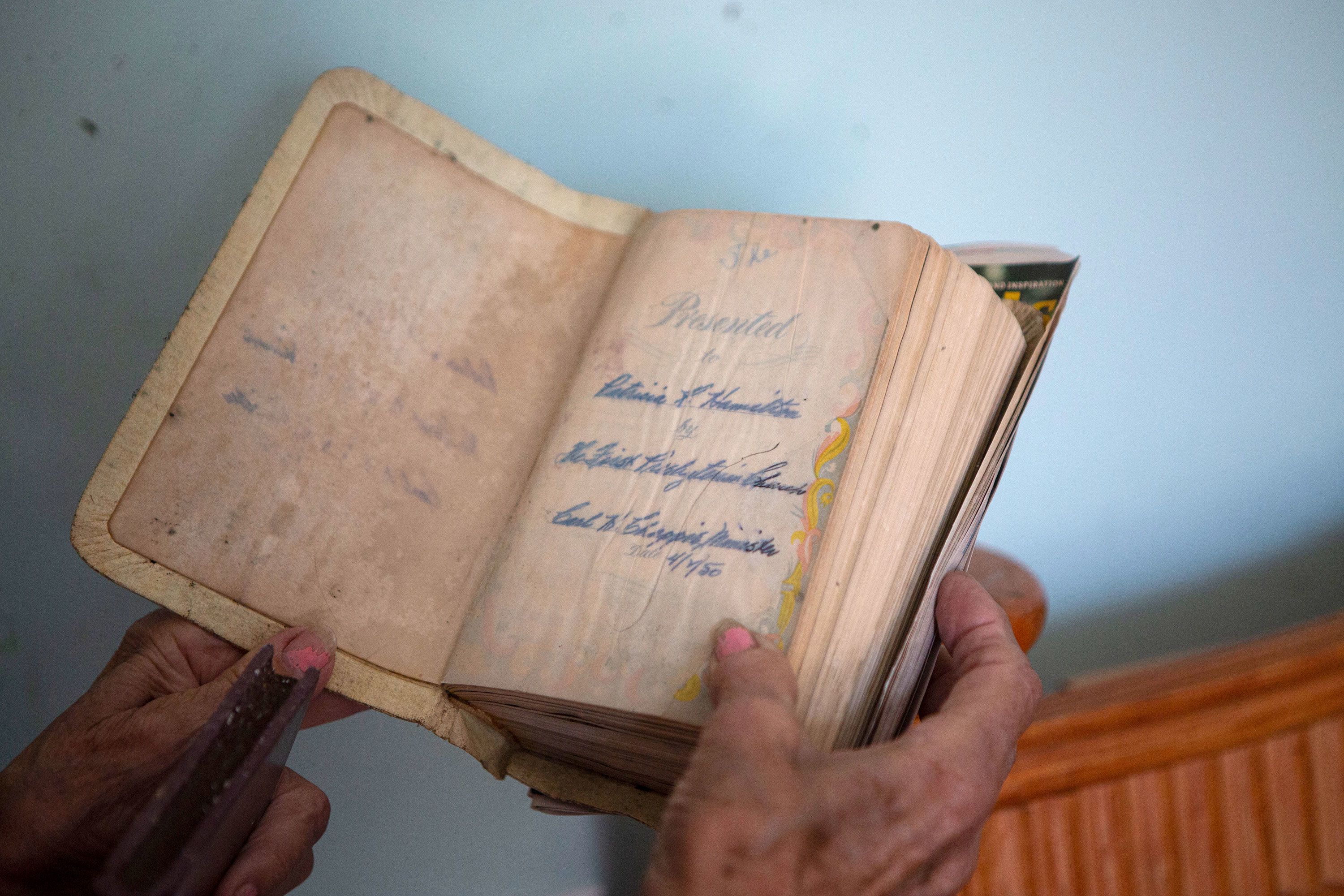 Pat Pickett, 83, tried to salvage a Bible given to her in 1950 that was damaged by floodwaters in her San Carlos Island home.