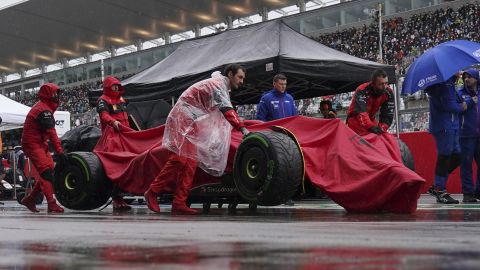 Carlos Sainz sin bil bæres i pit lane under regnforsinkelsen.