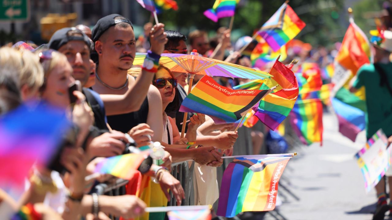 People wave Pride flags as they watch the New York City Pride Parade on June 26, 2022. The parade has been an annual tradition since it was first held in 1970 to observe the one-year anniversary of the Stonewall riots.