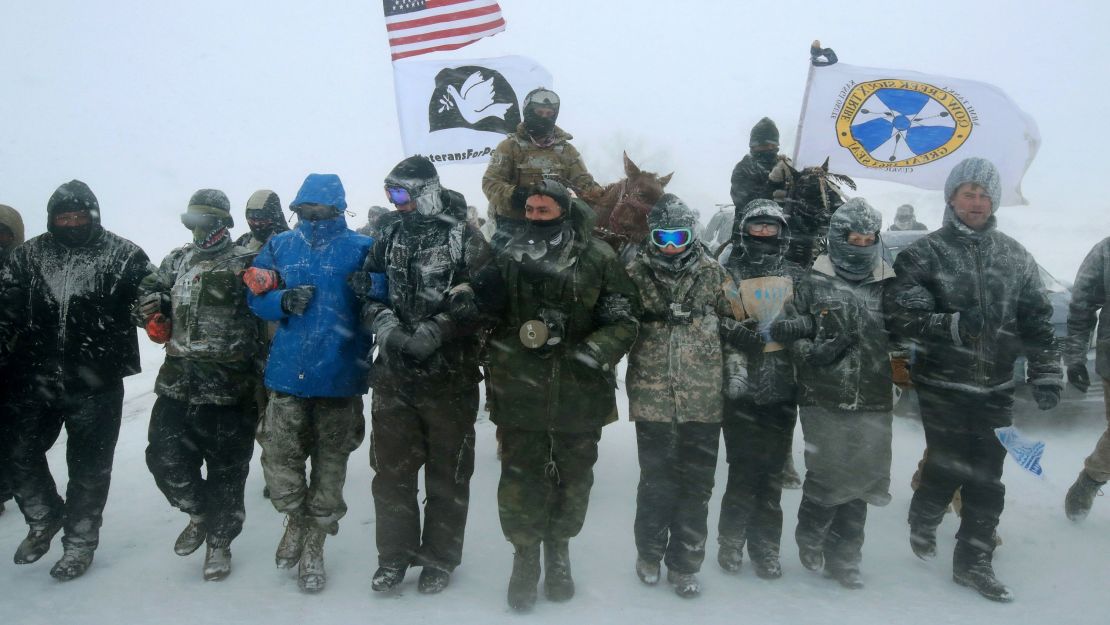 CANNON BALL, ND - DECEMBER 05:  Despite blizzard conditions, military veterans march in support of the "water protectors" at Oceti Sakowin Camp on the edge of the Standing Rock Sioux Reservation on December 5, 2016 outside Cannon Ball, North Dakota. Over the weekend a large group of military veterans joined native Americans and activists from around the country who have been at the camp for several months trying to halt the construction of the Dakota Access Pipeline. Yesterday the US Army Corps of Engineers announced that it will not grant an easement for the pipeline to cross under a lake on the Sioux Tribes Standing Rock reservation. The proposed 1,172-mile-long pipeline would transport oil from the North Dakota Bakken region through South Dakota, Iowa and into Illinois.  (Photo by Scott Olson/Getty Images)