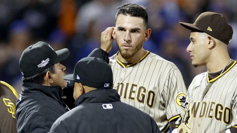 Crew chief Alfonso Marquez checks the ear of Joe Musgrove during the game between the Padres and the Mets.