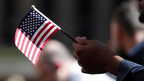 A citizenship candidate holds a flag during a naturalization ceremony in New York City on September 17, 2019. 