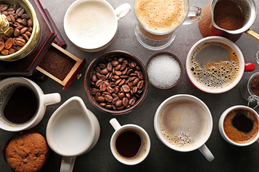 Different types of coffee in cups on dark table, top view
