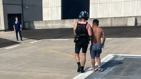 A Coast Guard rescue swimmer escorts one of the rescued boaters into University Medical Center New Orleans.