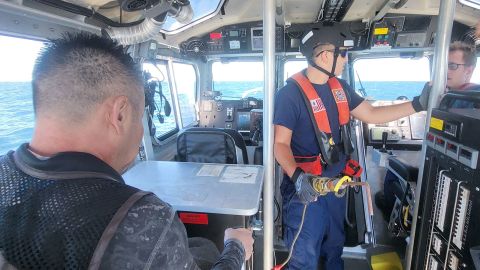 A Venice Coast Guard crew member treats two crew members for shark bites and hypothermia.