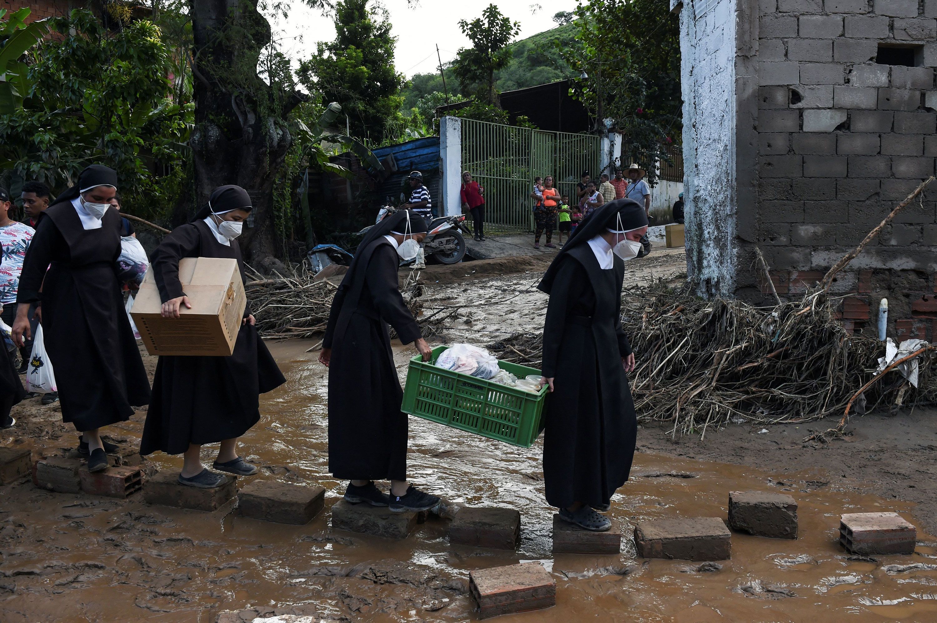 Nuns carry humanitarian aid to be distributed among the landslide victims on Monday.