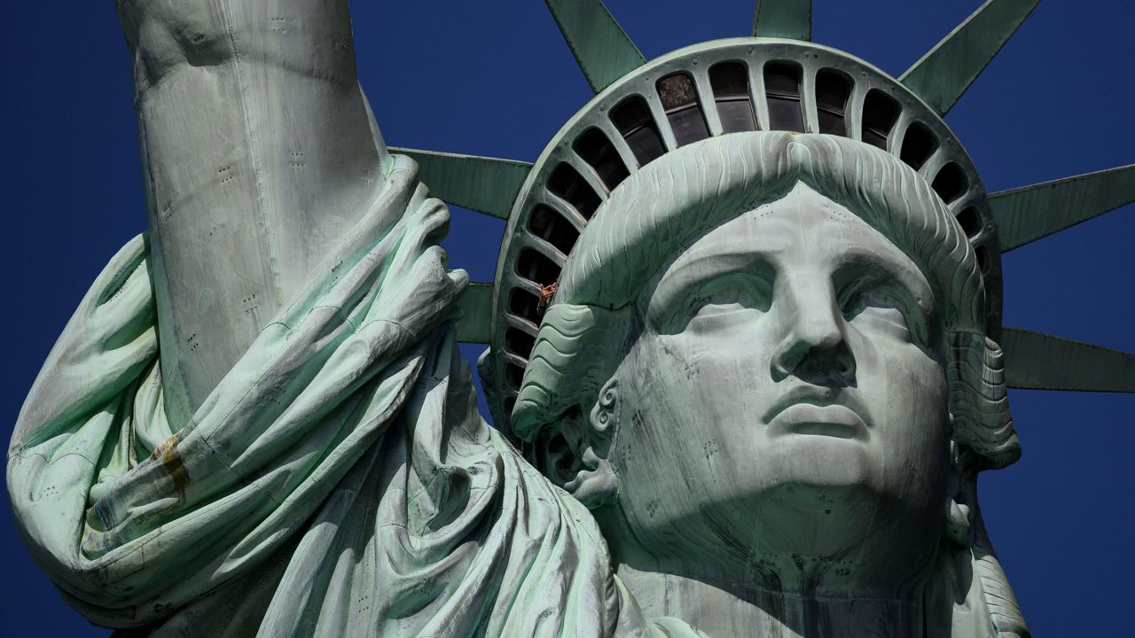 A tourist's hand is seen at the crown of the Statue of Liberty on February 19, 2019 in New York City. - The statue is a symbol for immigrants coming to the US. President Trump, on February 15, declared a "National Emergency" to justify tapping military and other funds for barrier construction at the border with Mexico. (Photo by Johannes EISELE / AFP)        (Photo credit should read JOHANNES EISELE/AFP via Getty Images)