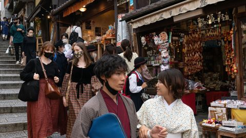 People walk down a shopping street in a touristy section of Kyoto, Japan, on October 11.