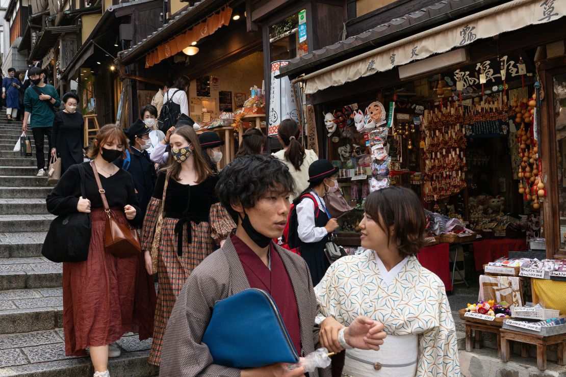 People walk down a shopping street in a touristy section of Kyoto, Japan, on October 11.