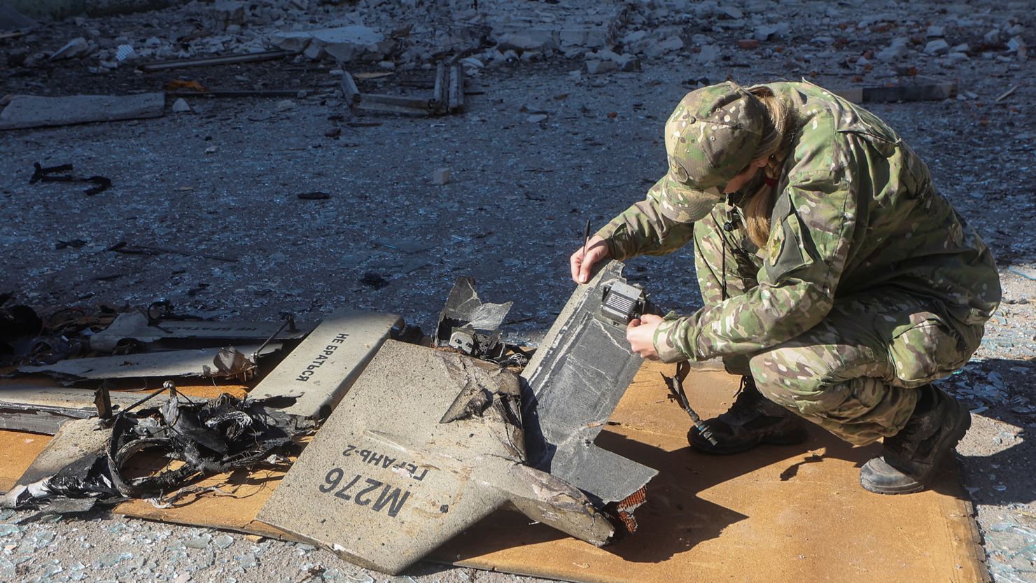 A police officer inspects parts of an unmanned aerial vehicle, what Ukrainian authorities consider to be an Iranian-made suicide drone, or Shahed-136, at the site of a Russian strike on fuel storage facilities in Kharkiv, Ukraine, on October 6.