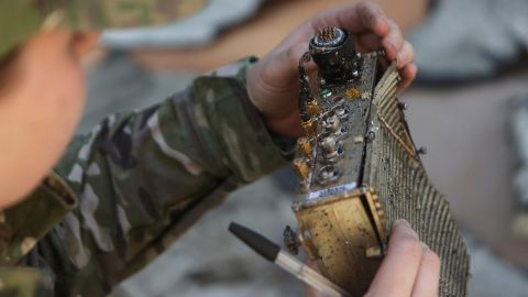 A Ukrainian police officer inspects a part of a shot-down drone in Kharkiv, on October 6, 2022.