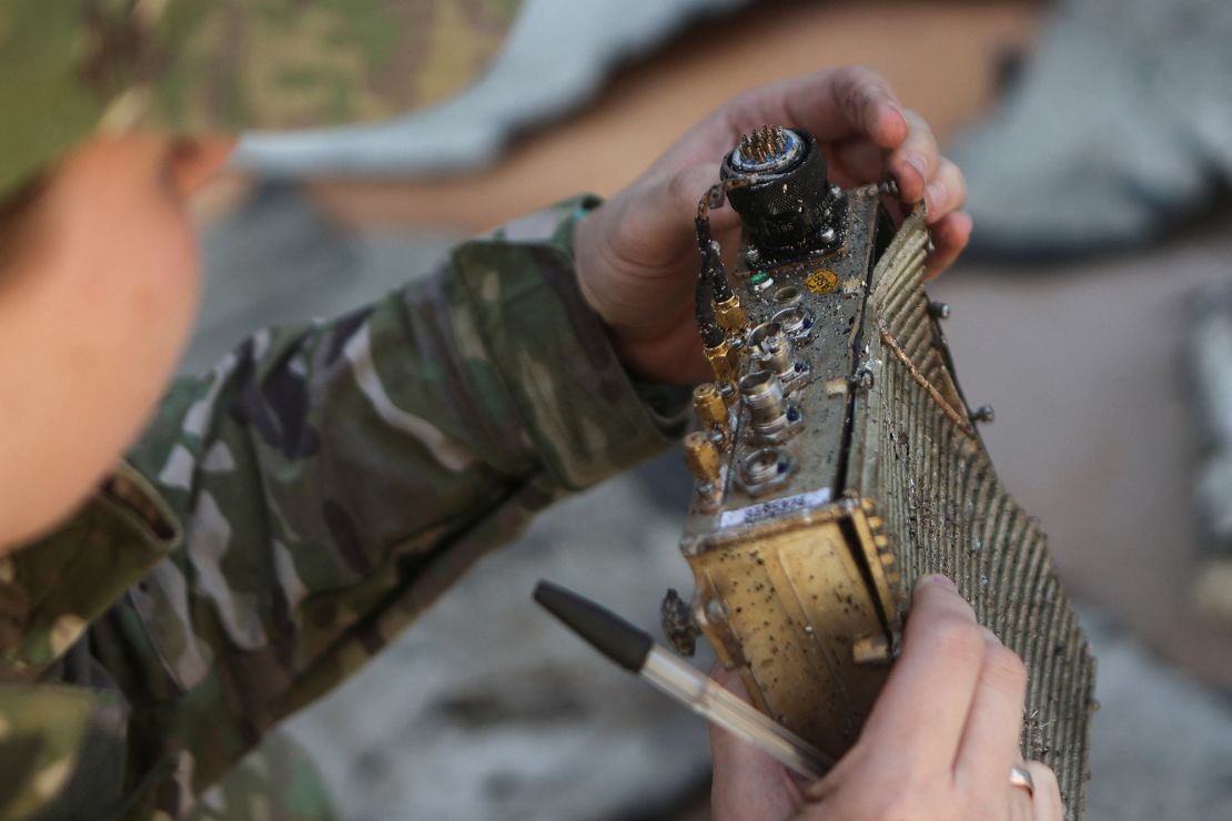 A Ukrainian police officer inspects a part of a shot-down drone in Kharkiv, on October 6, 2022.