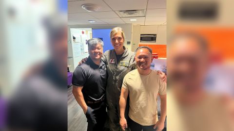 Coast Guard Lt. Katy Caraway reunites with survivors Phong Le, left, and Luan Nguyen.