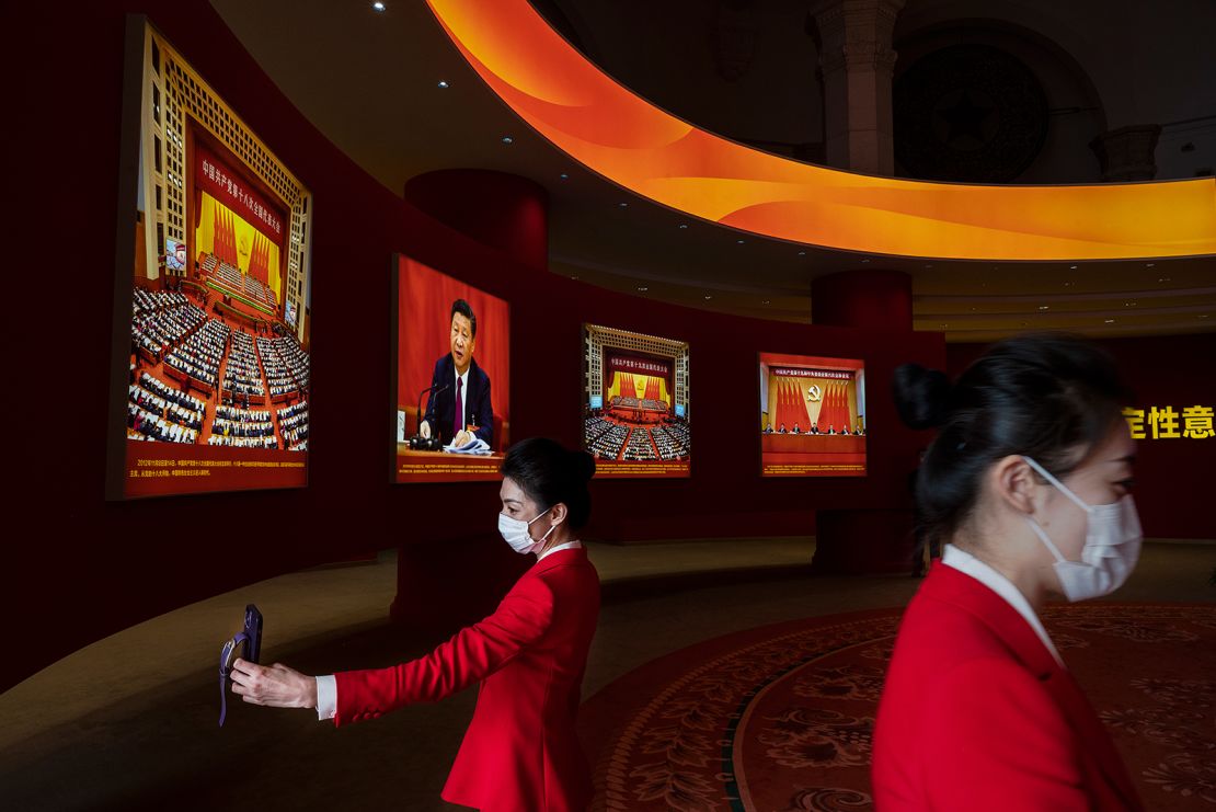 Hostesses stand near images showing Chinese President Xi Jinping at an exhibition highlighting Xi's years as leader, as part of the upcoming 20th Party Congress, on October 12, 2022 in Beijing, China.