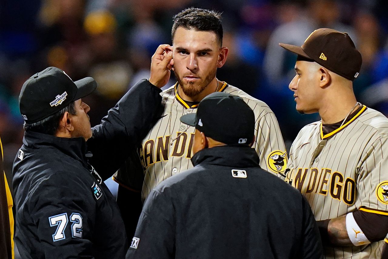 Umpire Alfonso Marquez checks for foreign substances behind the ears of San Diego starting pitcher Joe Musgrove during a playoff baseball game in New York on Sunday, October 9. <a href=