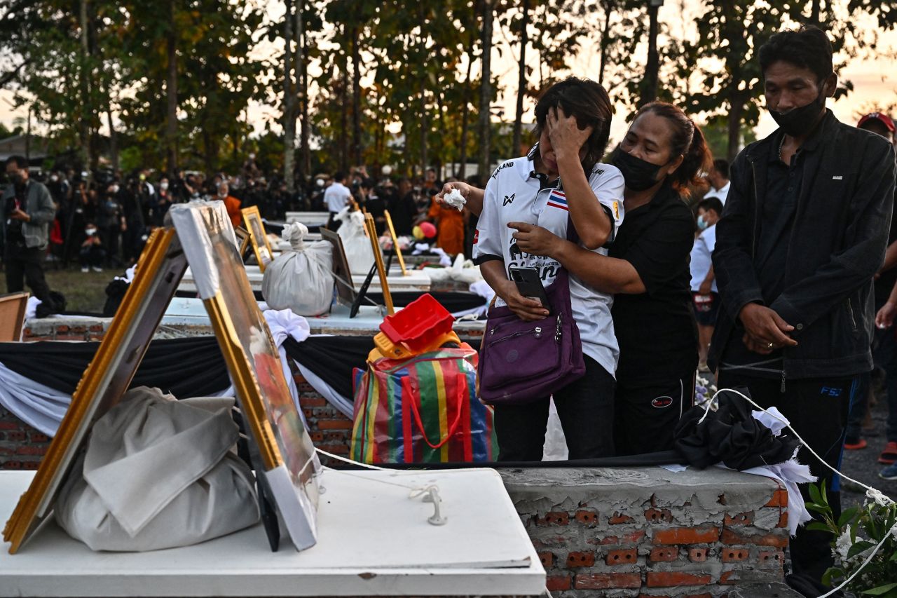 Relatives mourn Tuesday, October 11, next to the coffins of children who were killed last week at a day care center in northeastern Thailand. There were 36 people killed in <a href=