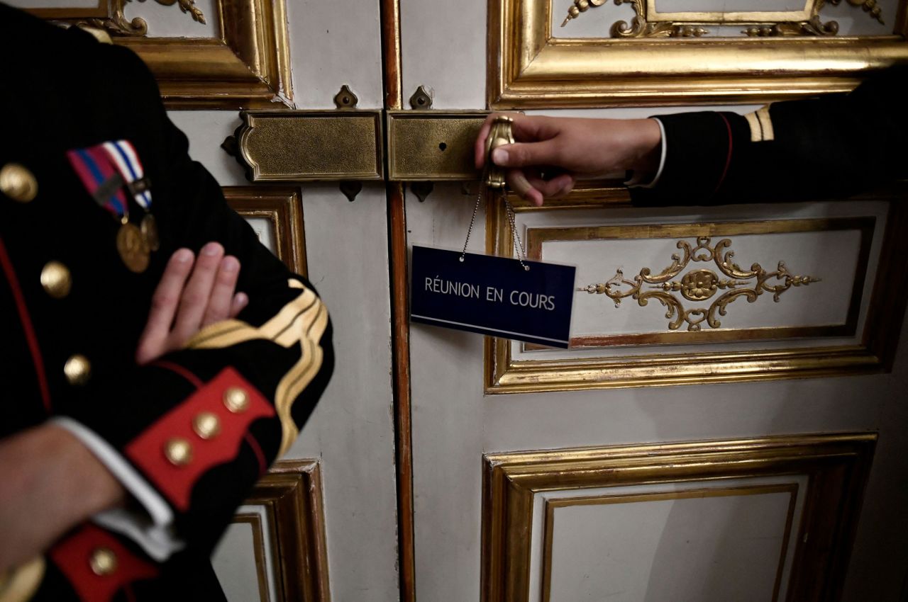 A sign that translates to "ongoing meeting" is displayed on a door at the Matignon Hotel in Paris on Monday, October 10. French government officials were meeting to discuss the country's supply of fuel. Striking workers have blockaded ExxonMobil and TotalEnergies refineries for several weeks, <a href="https://www.cnn.com/2022/10/12/energy/france-refinery-strike-exxonmobil" target="_blank">disrupting supply to thousands of gas stations.</a>