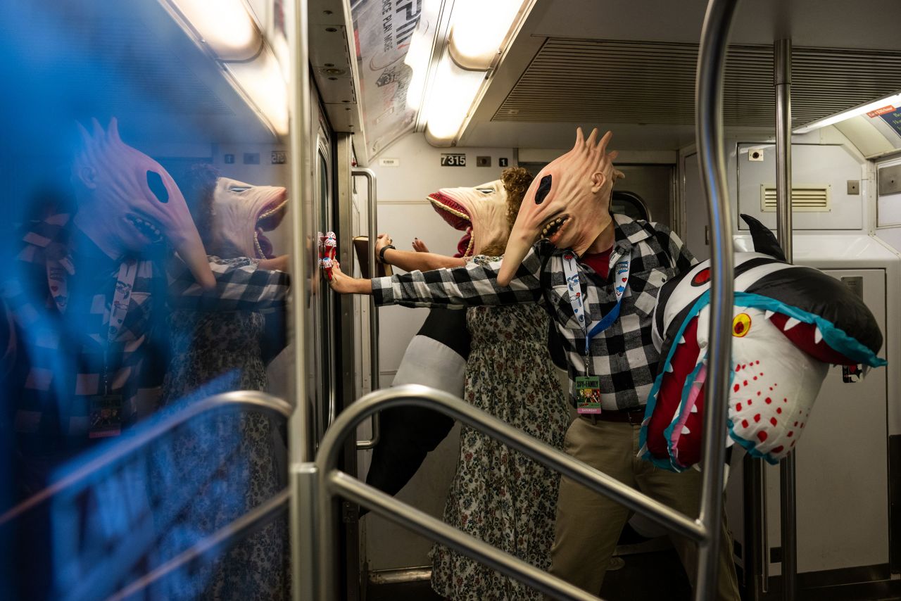 People dressed as Adam and Barbara Maitland from the movie "Beetlejuice" ride the subway after leaving New York Comic Con on Saturday, October 8. 