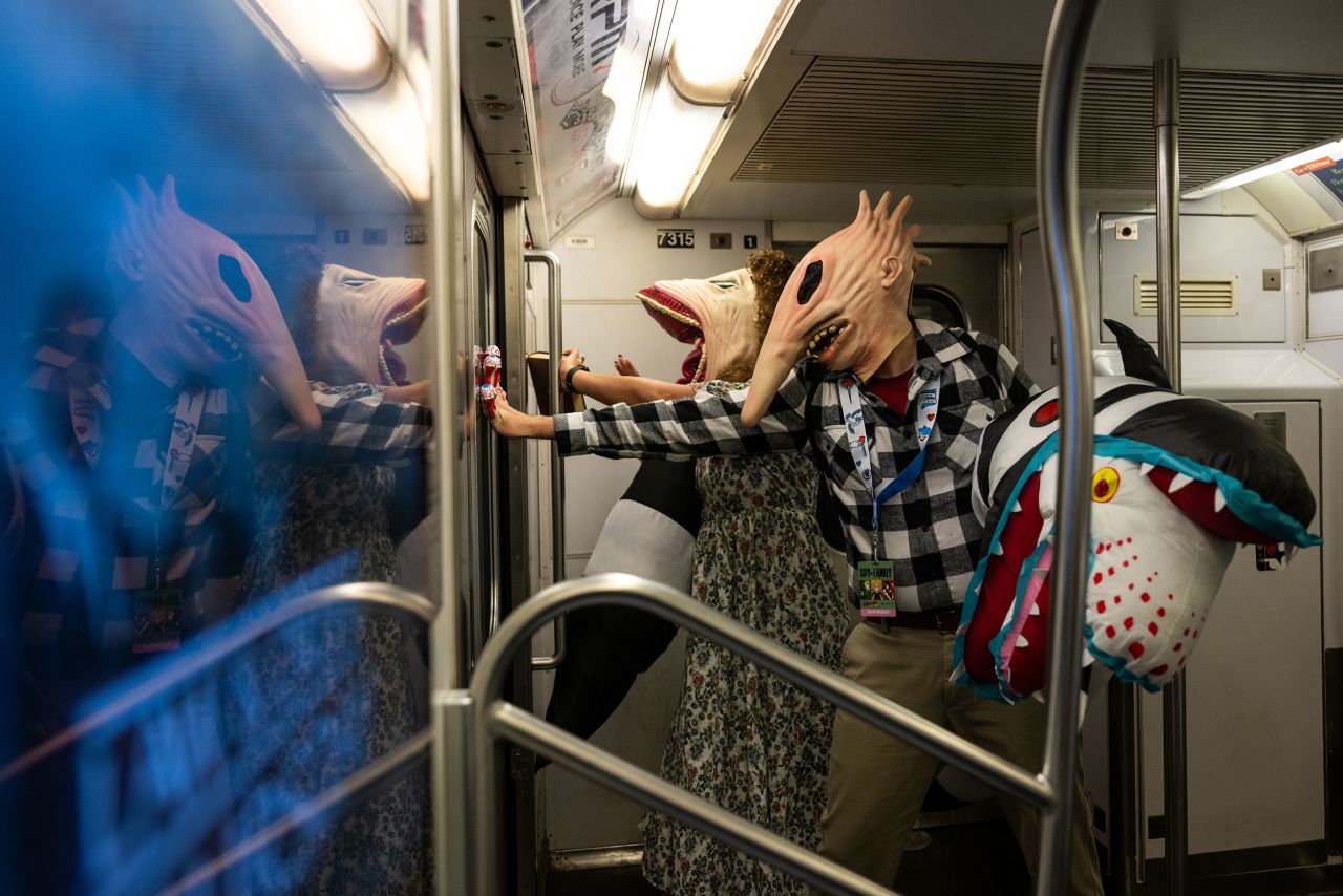 People dressed as Adam and Barbara Maitland from the movie "Beetlejuice" ride the subway after leaving New York Comic Con on Saturday, October 8.