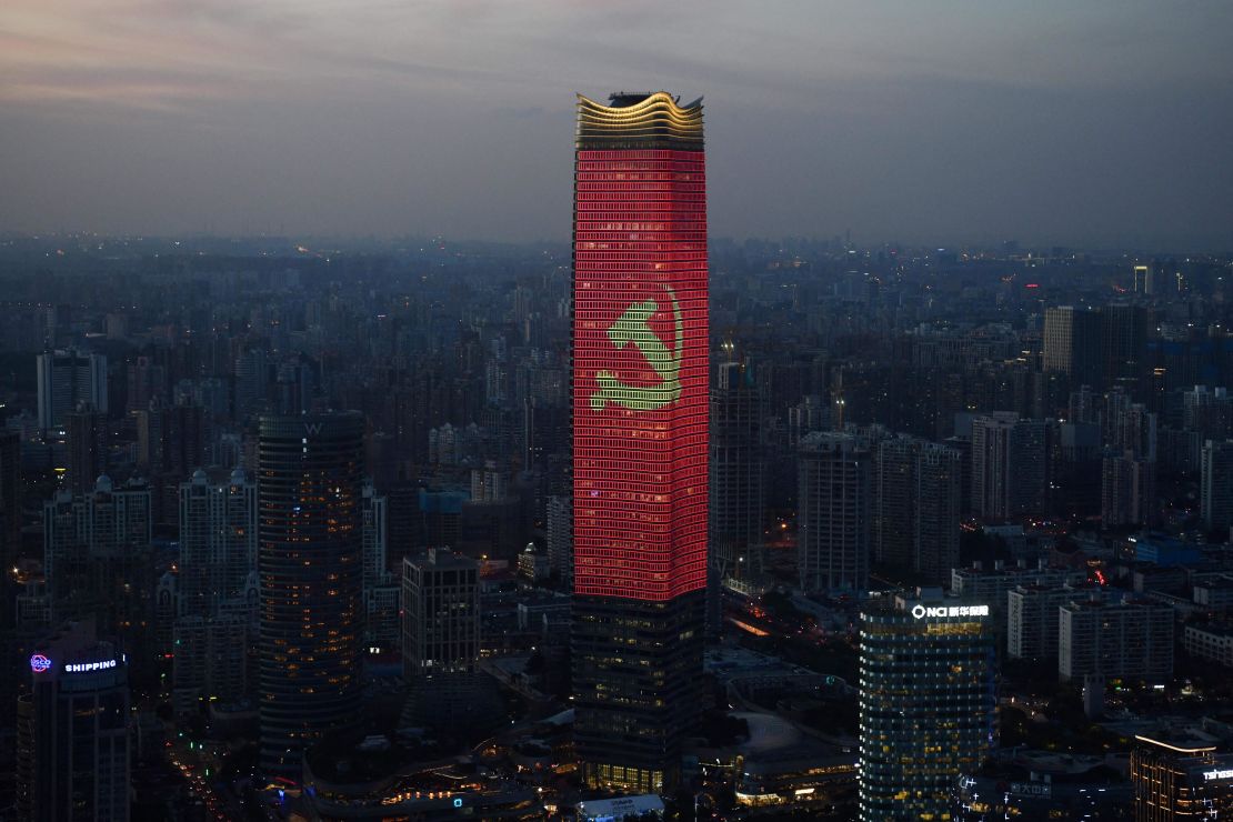 The Communist Party logo is seen on a skyscraper in Shanghai at dusk.