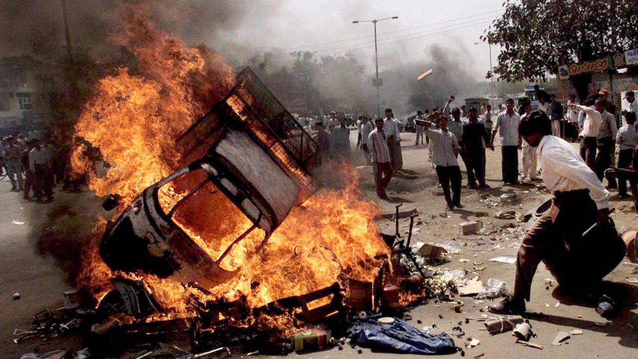 Protesters burn vehicles during riots in Ahmedabad, India, February 28, 2002.