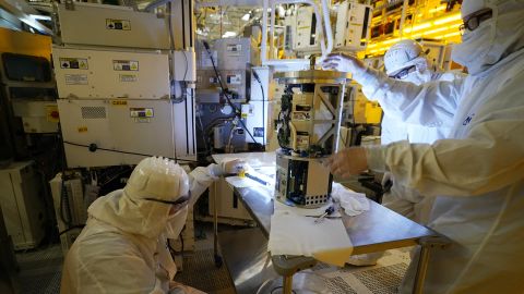 Technicians inspect a piece of equipment during a tour of the Micron Technology automotive chip manufacturing plant Feb. 11, 2022, in Manassas, Va. 