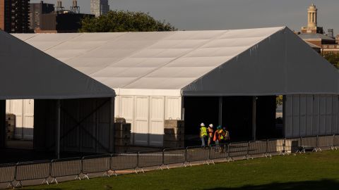 Workers construct large tent shelters on Randall's Island in New York City to help handle an influx of asylum seekers.