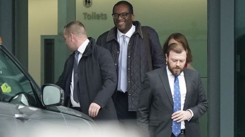 Kwasi Kwarteng (second left) arrives at London Heathrow Airport on Friday after being summoned back from the US.