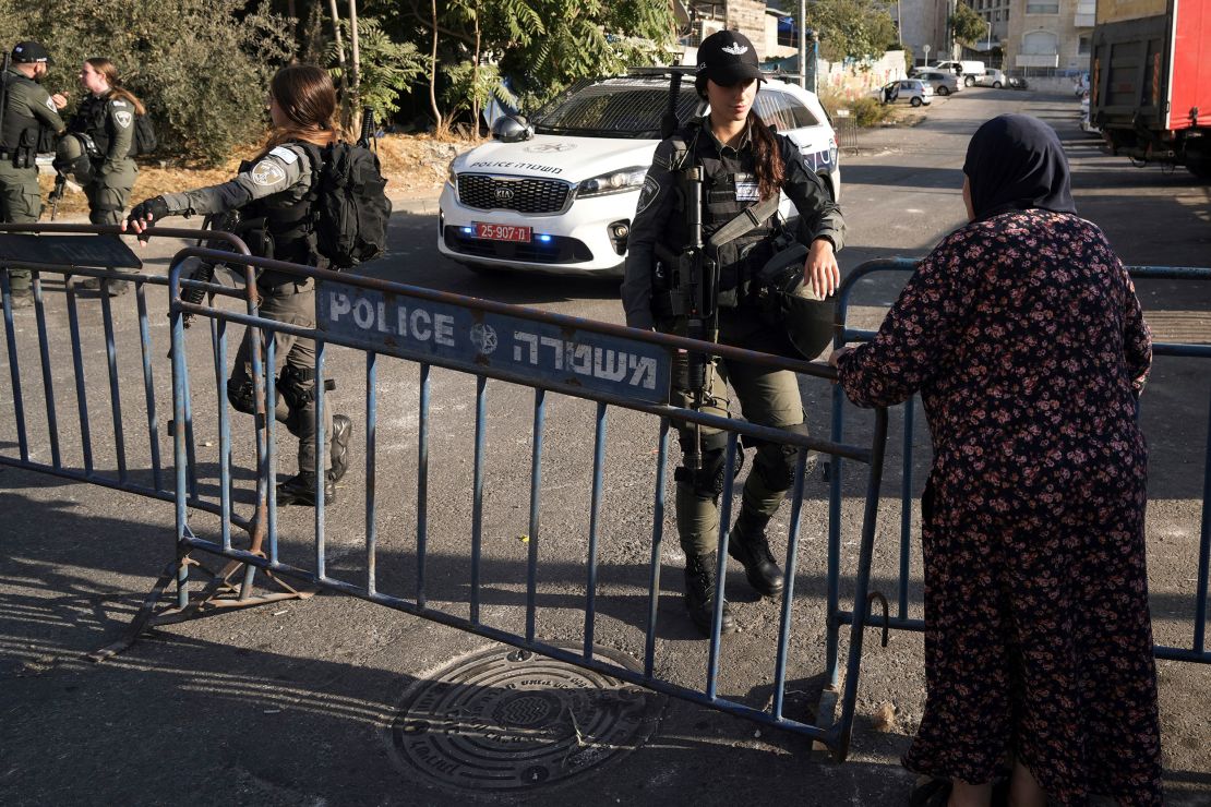 An Israeli Border Police officer talks to a Palestinian woman on October 14.