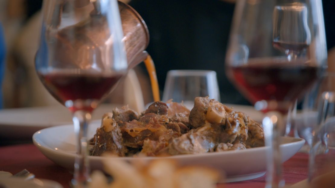Chef Pino Trimbol pours the juices from the lamb over the home-style Calabrian dish.
