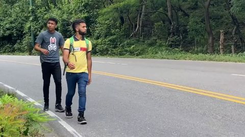 Mario Mosquera and Jefferson Lozada, two Venezuelan cousins, walk along a highway in eastern Guatemala.