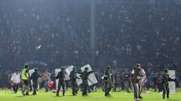 This picture taken on October 1, 2022 shows members of the Indonesian army securing the pitch after a football match between Arema FC and Persebaya Surabaya at Kanjuruhan stadium in Malang, East Java.