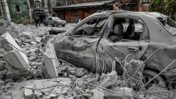 A woman stands near her destroyed car near an old mill, built around 1885, also destroyed during a Russian missile attack in Zaporizhzhia, Ukraine October 14, 2022.