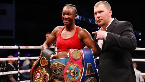 Shields celebrates winning with her belts after the WBO, WBA, IBO and WBF women's middleweight title fight against Erna Kozin.
