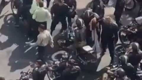 Iranian police said they were responding to a video from Tehran that shows a large group of male security forces surrounding and grabbing a women's rights leader.