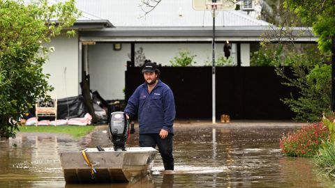 A man pushes a boat as floodwaters inundate a Victorian residential area in Rochester, Australia, on October 14, 2022.  
