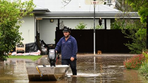 A man pushes a boat as floodwaters inundate a Victorian residential area in Rochester, Australia, October 14, 2022.