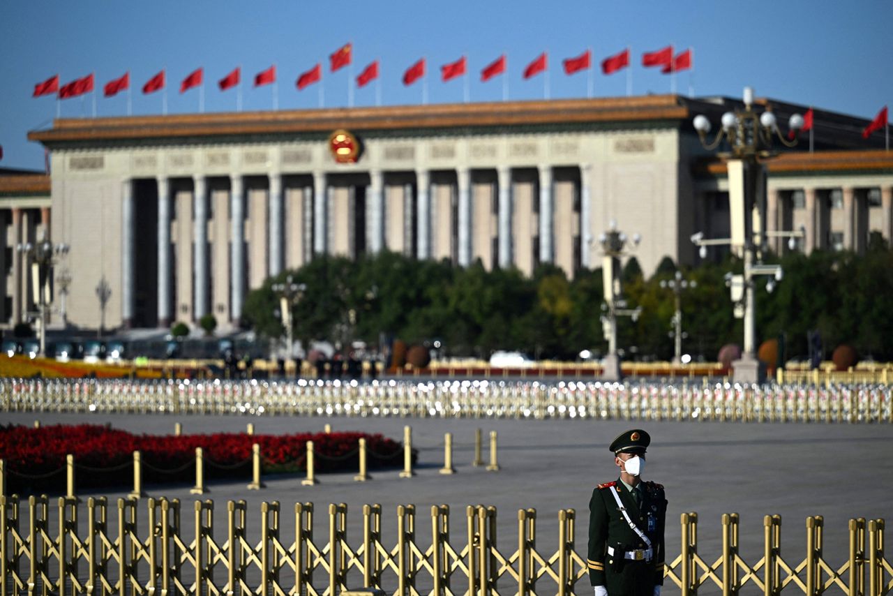 A security guard stands outside the Great Hall of the People.