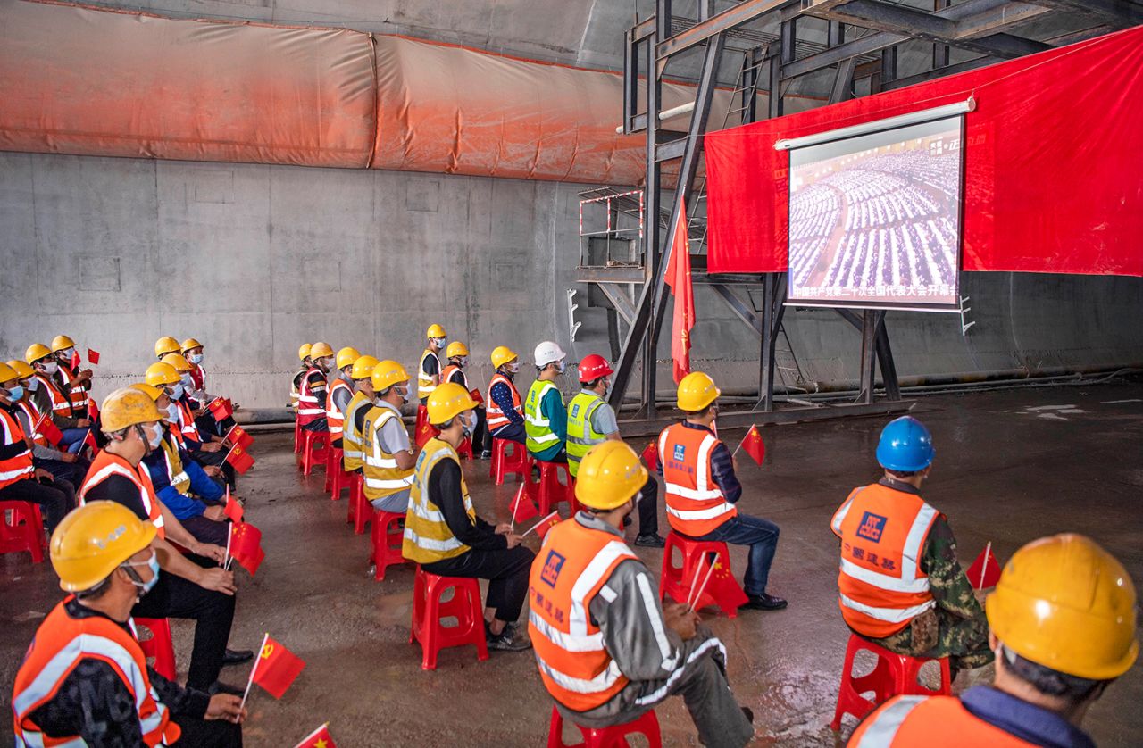 Construction workers in Changsha, China, watch a live broadcast of the opening session.