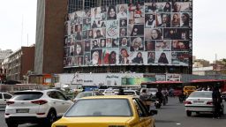 Iranians drive past a huge billboard showing a montage of pictures titled the women of my land, featuring Iranian women who are all observing the hijab, on Valiasr Square in Tehran, on October 13.