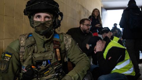 Los militares y los trabajadores de rescate se ponen a cubierto cuando un edificio en la capital de Ucrania es sacudido por explosiones durante un ataque con drones a primera hora de la mañana del 17 de octubre.