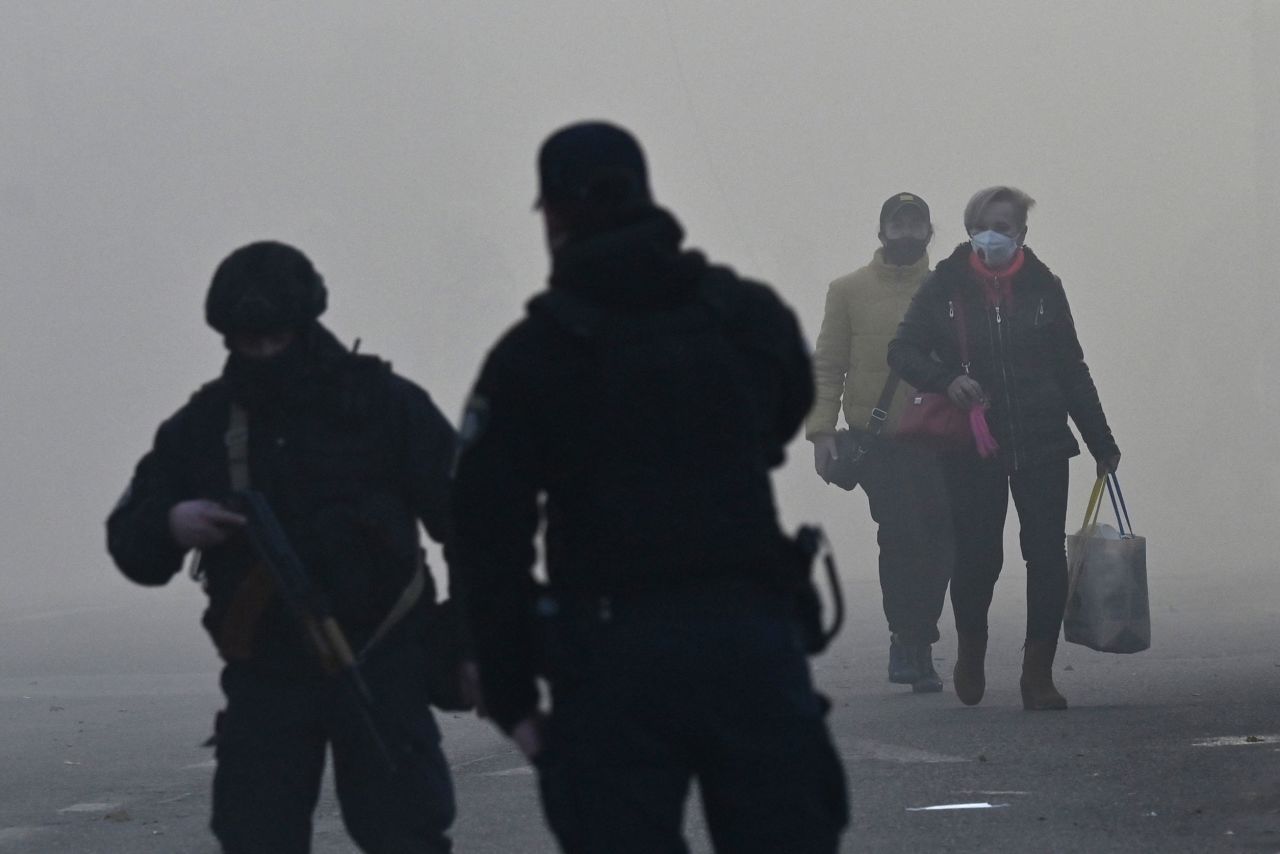 People walk through smoke after a drone attack in Kyiv.