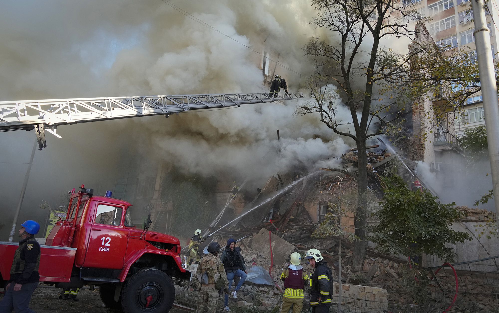 Firefighters work on a building damaged after a drone attack, in Kyiv on Monday.