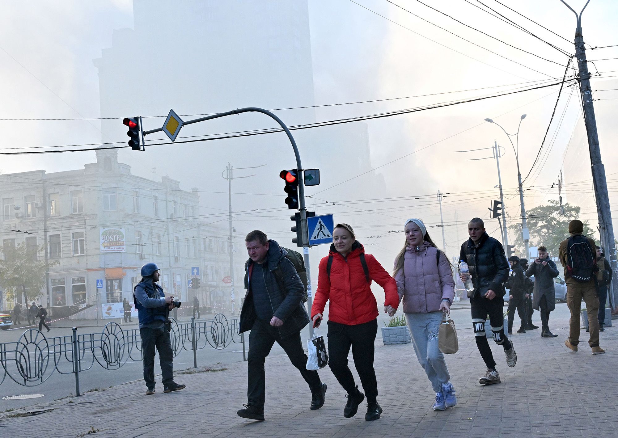 Local residents run away after a drone attack in Kyiv on Monday.