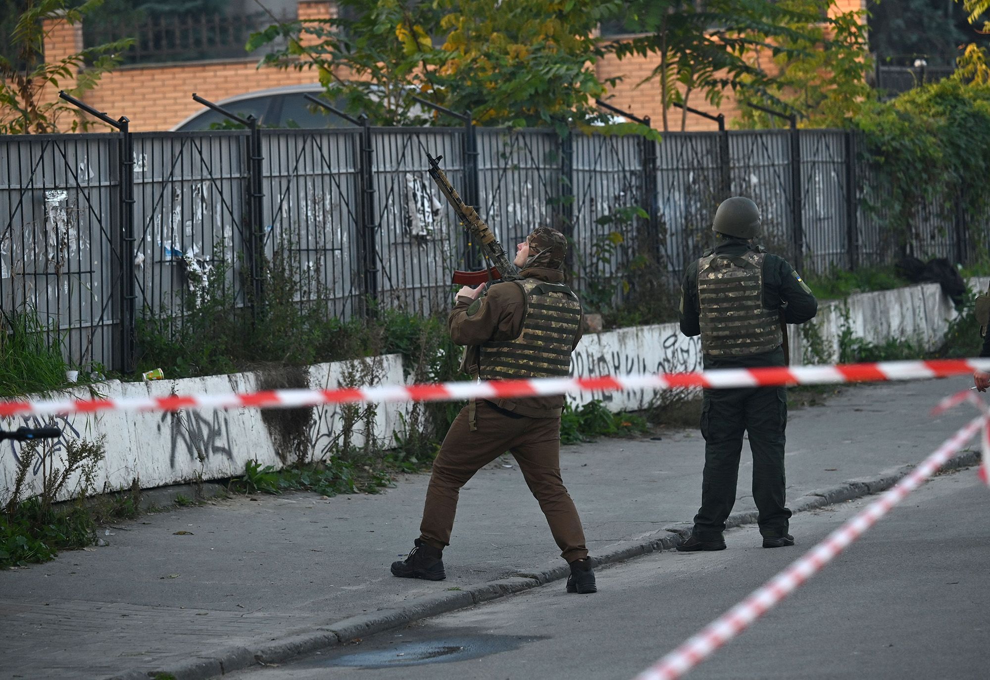 A Ukrainian serviceman attempts to shoot down a drone during an attack in Kyiv on Monday.