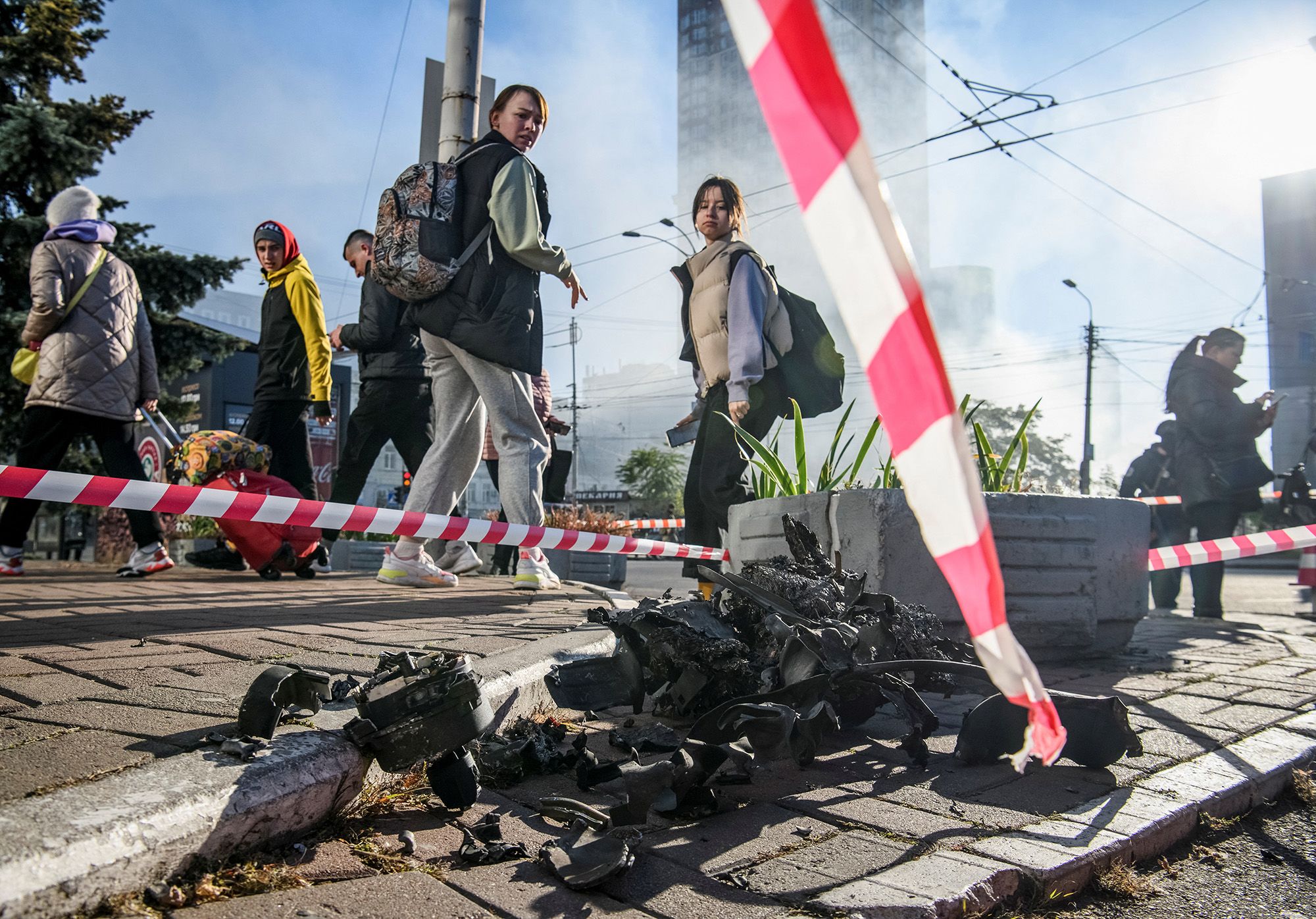 Local residents look at parts of a drone that Ukrainian authorities consider to be an Iranian-made drone Shahed-136, in Kyiv.