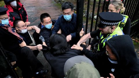 A man is pulled at the gate of the Chinese consulate after a demonstration against China's President Xi Jinping, in Manchester, Britain, October 16.